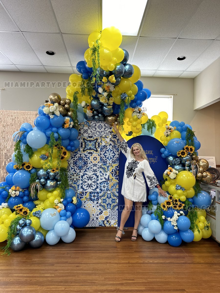 Olesia Standing Beside A Large Blue And Yellow Balloon Installation