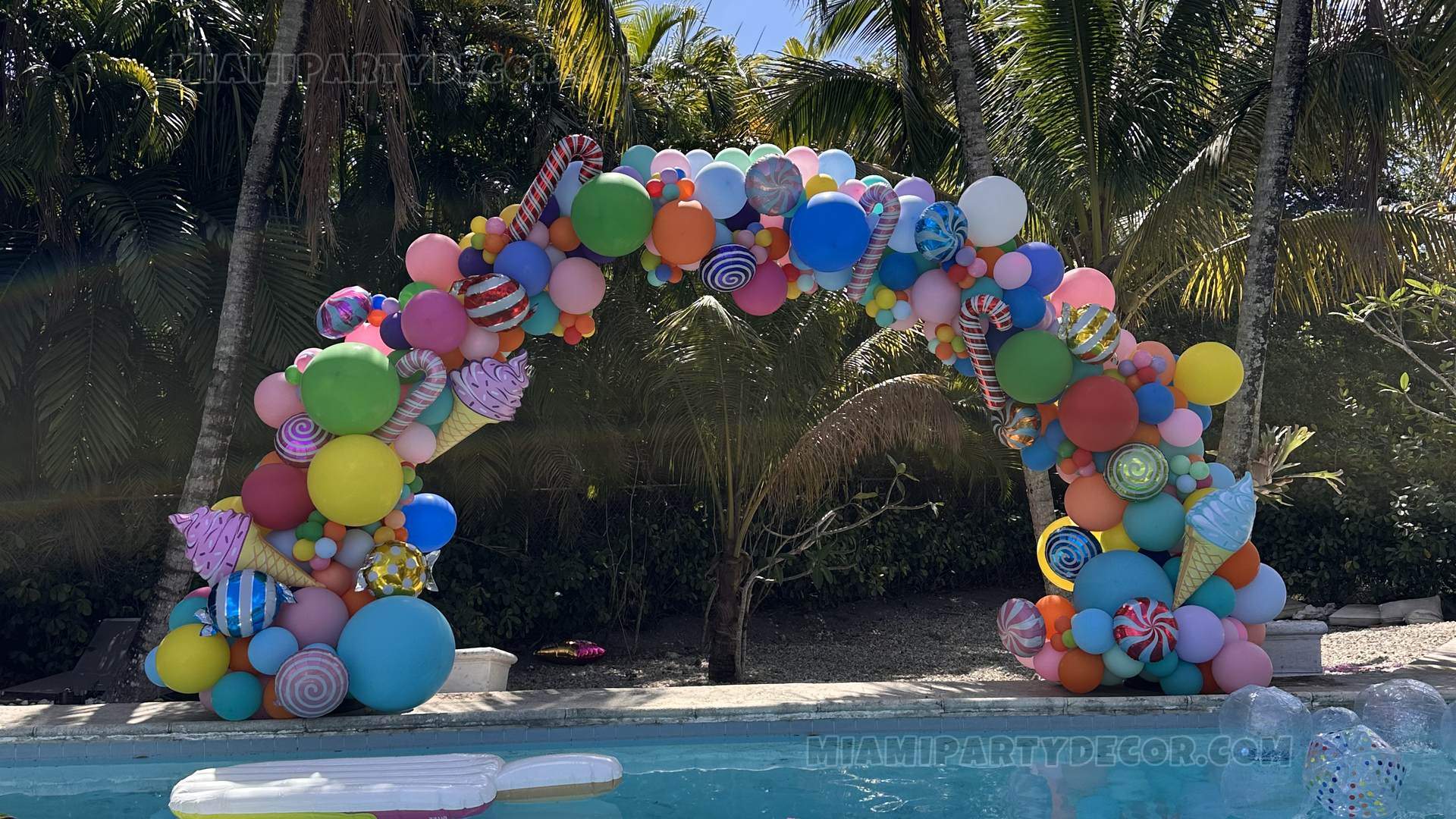 Colorful Balloon Arch Over A Swimming Pool